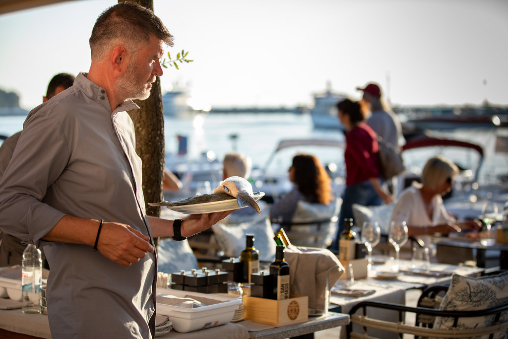 Comparatif des outils pour recruter et gérer les extras en restauration Serveur en terrasse portant une assiette pendant le service d'un restaurant