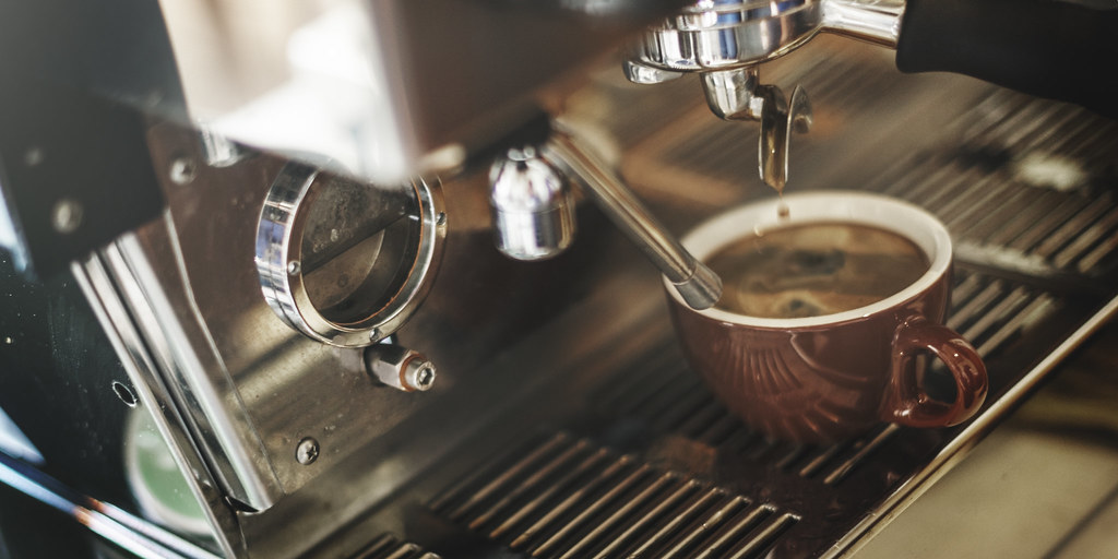 Comparatif des logiciels de recrutement pour l'hôtellerie-restauration Machine à café professionnelle préparant un expresso dans un établissement CHR
